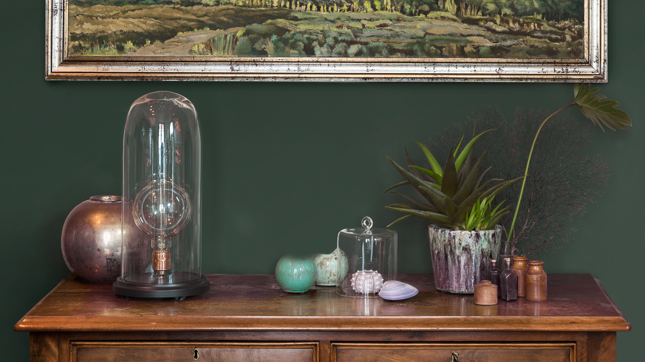Green wall A deep, rich colour sets the tone for displaying antique objects.