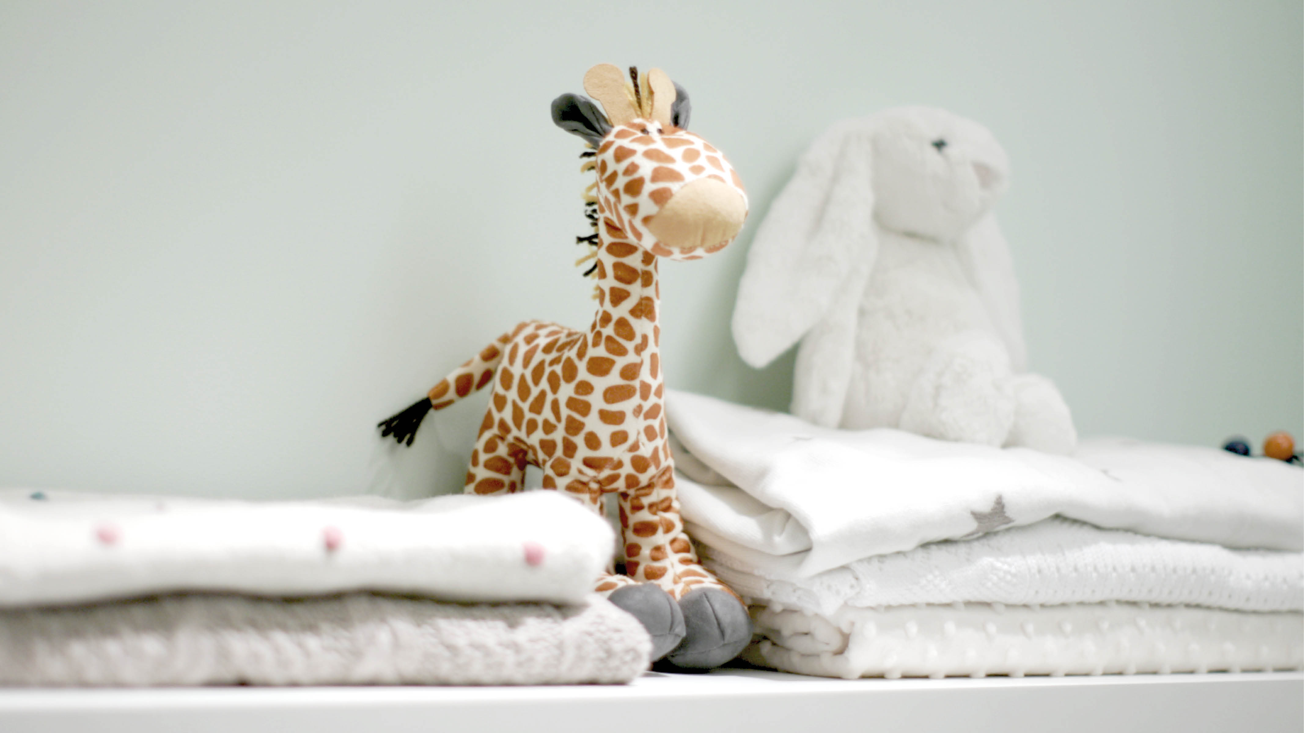 Floating shelves in nursery To avoid the space being overwhelmed with nappies and lotions, choose moveable, stackable storage units that can easily fit underneath the crib or sofa bed.