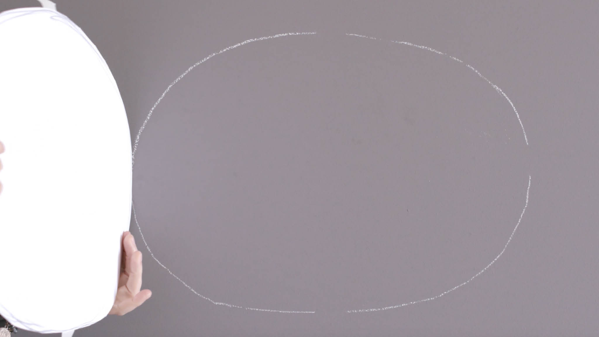 Chalked oval on wall Use chalk to draw around your oval shape
